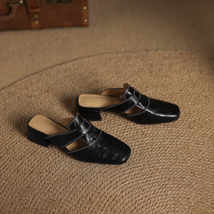 Pair of black leather mules with square toe, vamp strap, and low block heels
