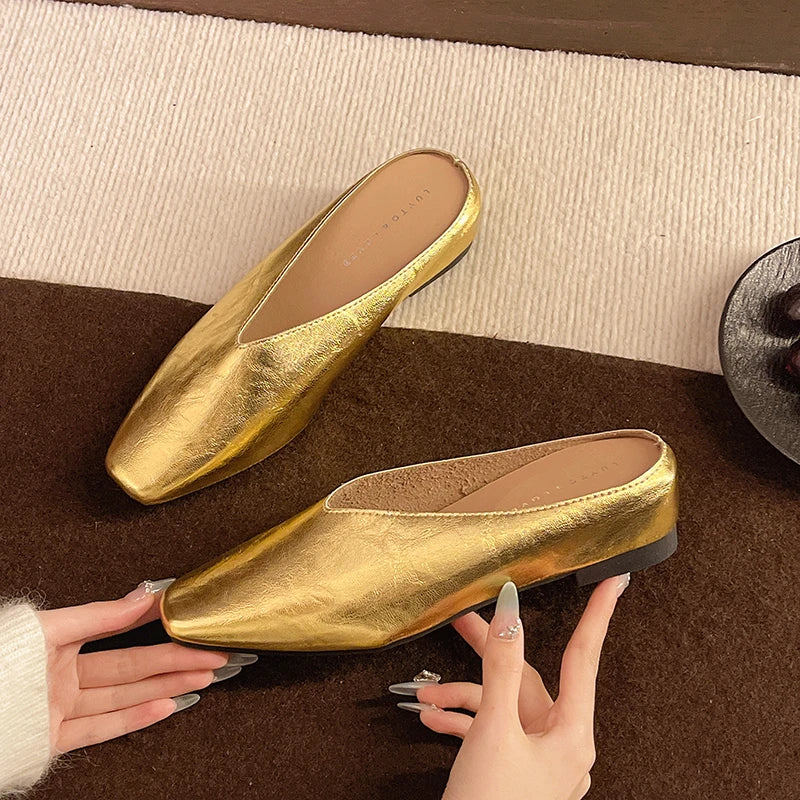 Gold metallic Lyra mules with pointed toe and low block heel, slip-on style