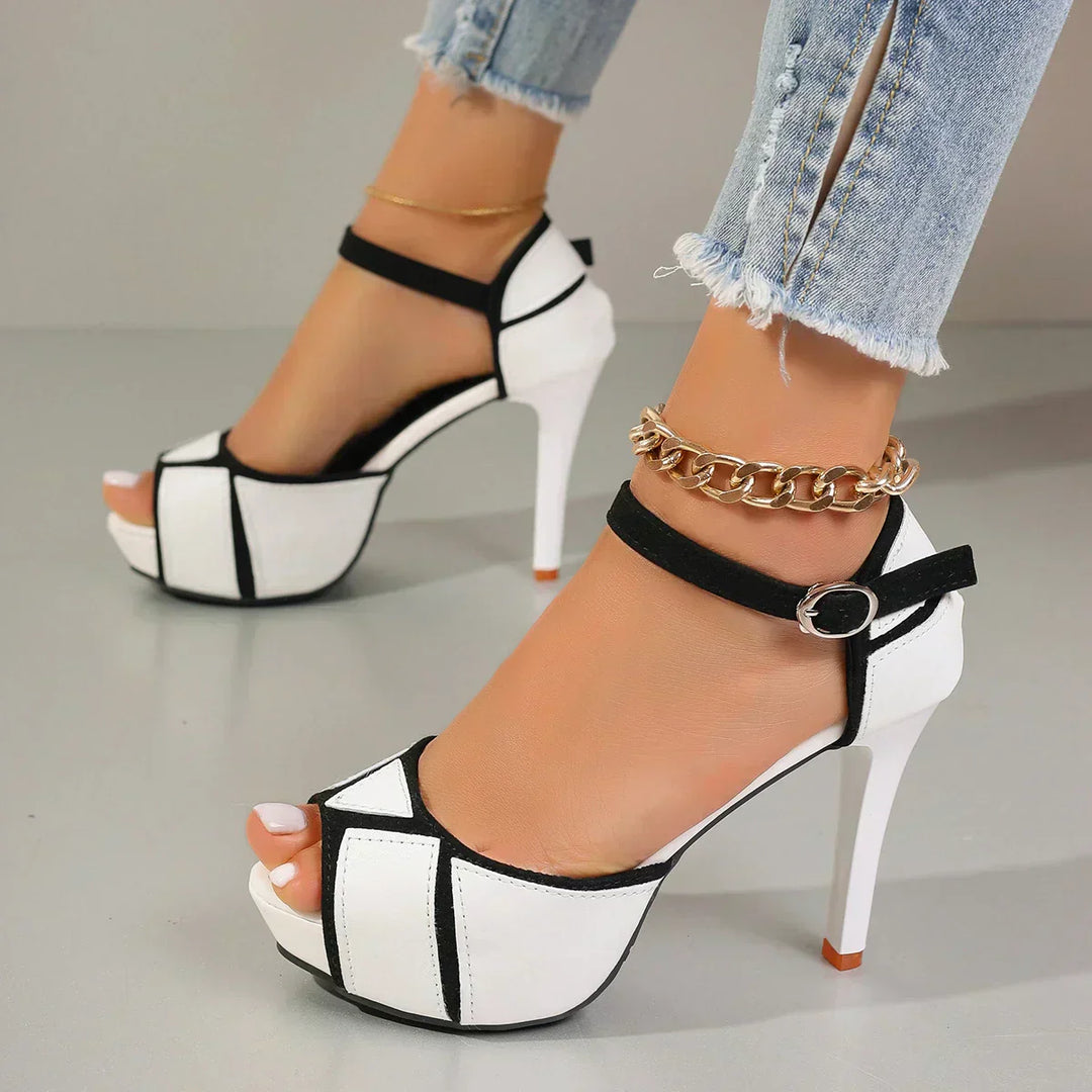 White-and-black platform heeled sandals with open toe and ankle strap with buckle