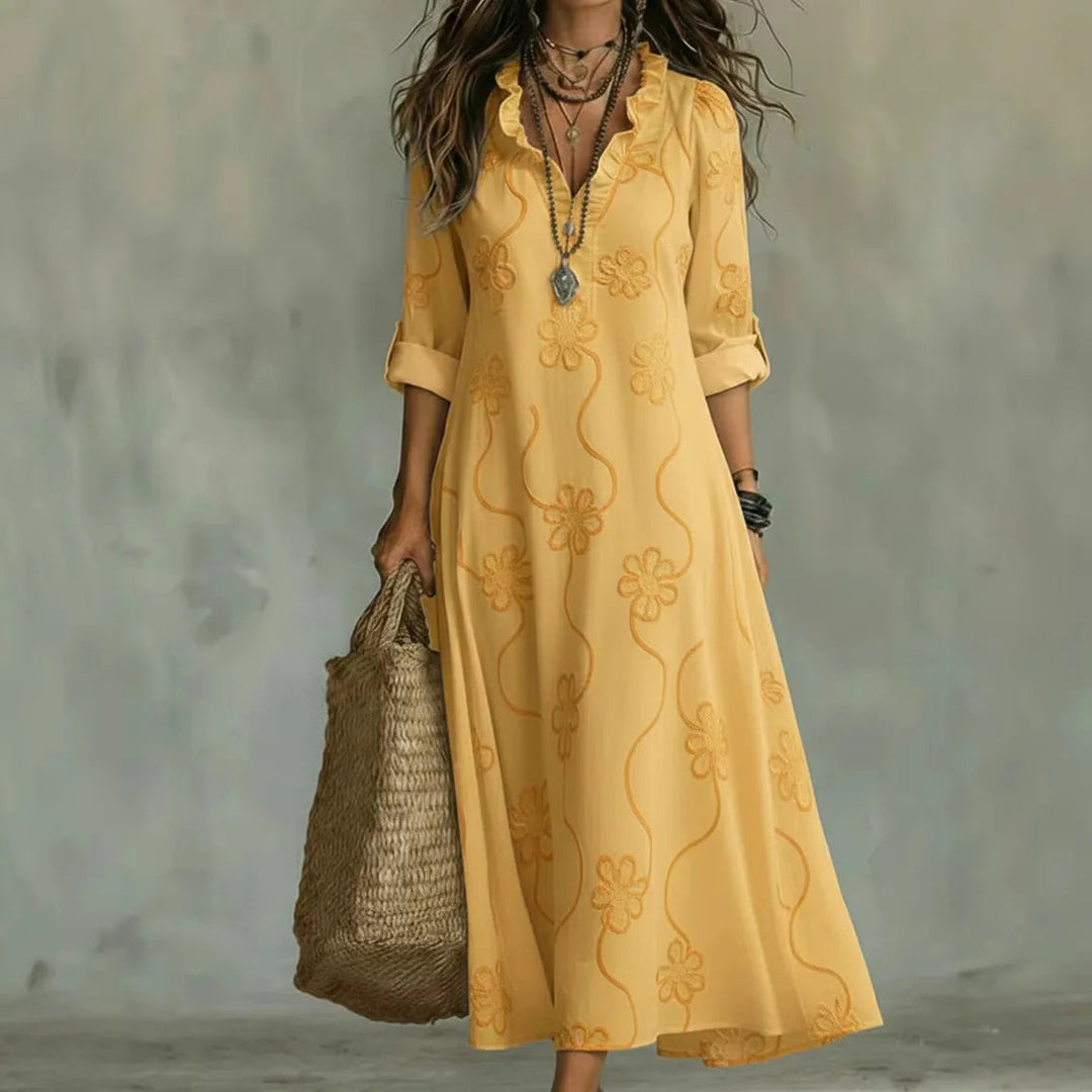 Yellow maxi dress with short sleeves and subtle floral pattern, V-neck.