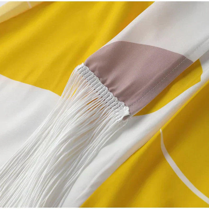 Smocked waist detail with white fringe trim on abstract yellow and taupe skirt