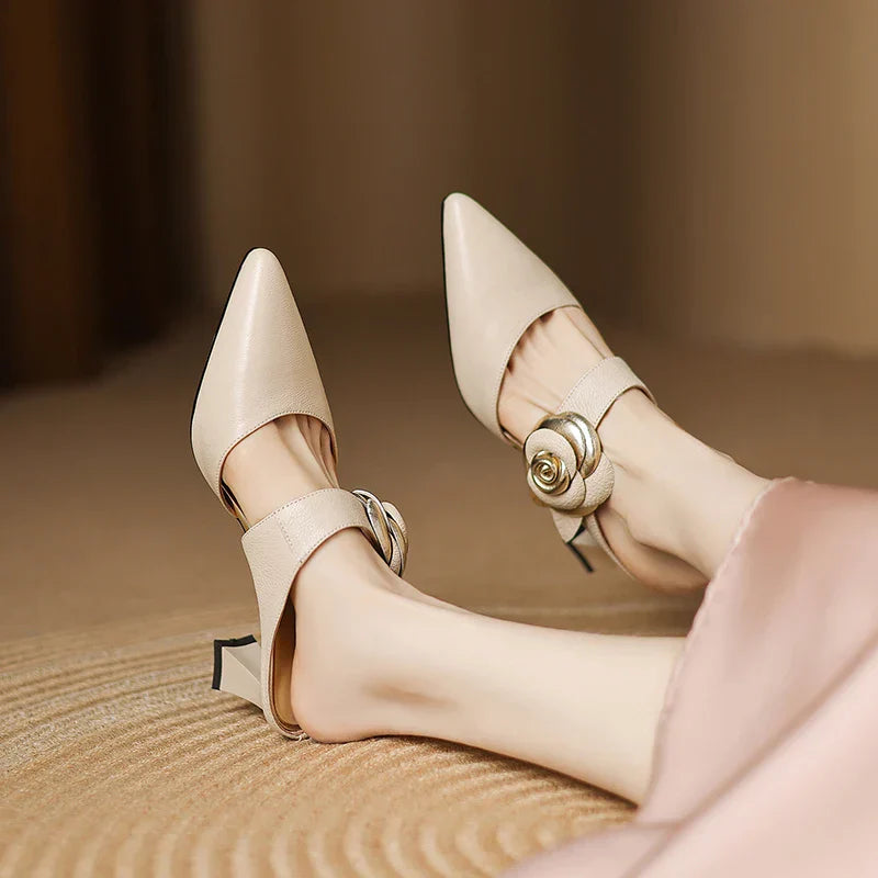 Beige heeled slingbacks with pointed toe, ankle strap, rosette buckle, and block heel
