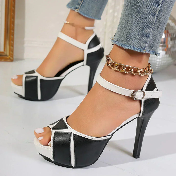 White-and-black open-toe platform heels with ankle strap and round buckle, side view
