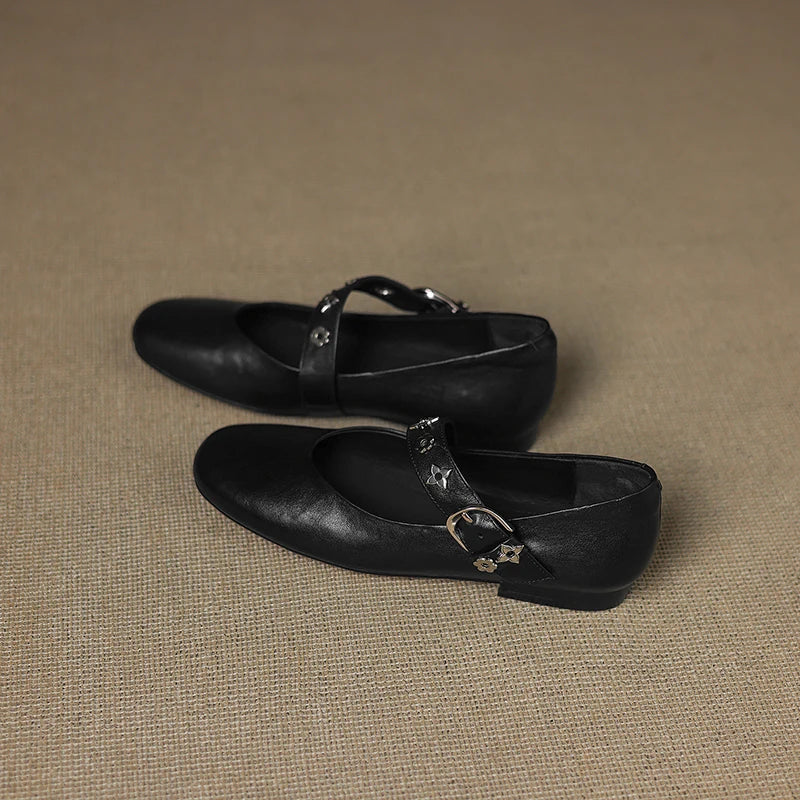 Black leather loafer flats with star accent strap and buckle