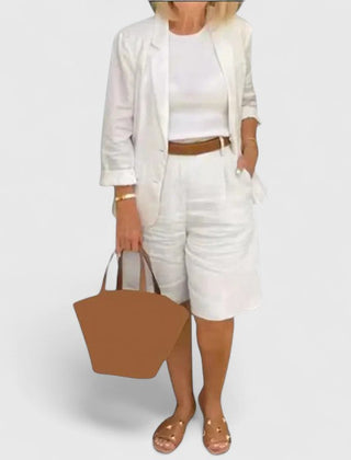 White 2-piece suit set with blazer jacket and shorts, with brown waist belt and tote