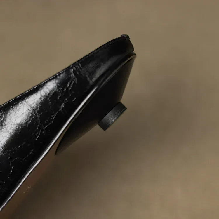 Black leather mule with pointed toe and low block heel, slip-on design.