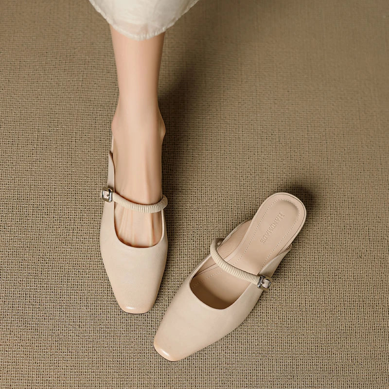 Beige Mary Jane mules with elastic ankle strap, square buckle, and low block heel