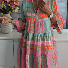 Women's tiered dress with teal, pink, and orange geometric print, long sleeves