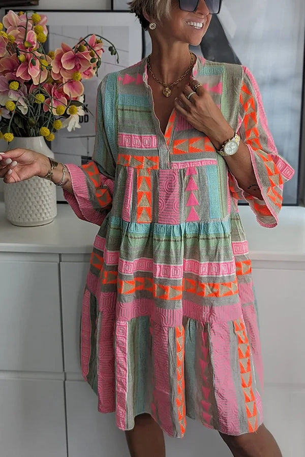 Boho spring dress with v-neck placket, long sleeves, and tiered geometric print
