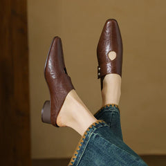 Brown leather mule with open side cutout and small stud detail, low block heel