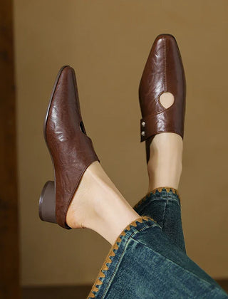 Brown leather mule with open side cutout and small stud detail, low block heel