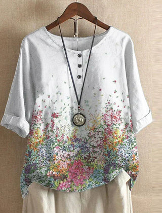 Women’s white floral blouse with colorful garden print, button-front, short sleeves.