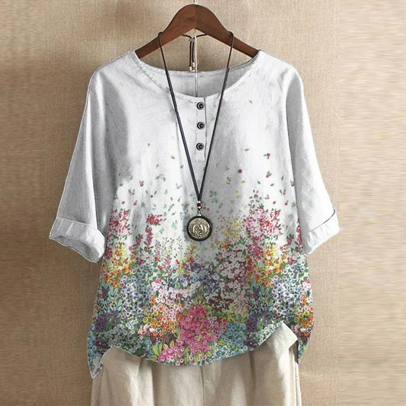 Women’s white floral blouse with colorful garden print, button-front, short sleeves.