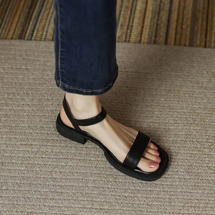 Black leather platform sandals with open toe and ankle strap