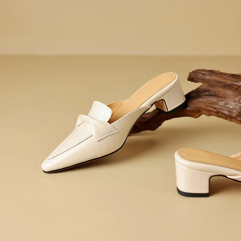 Two beige leather mules with pointed toe and low block heel