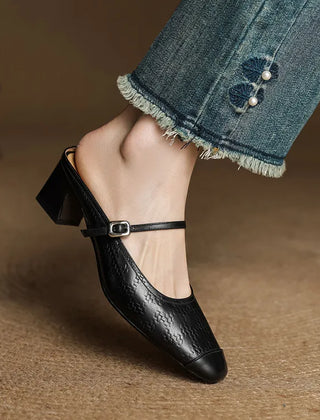 Black embossed leather mule with square toe, ankle strap, and block heel