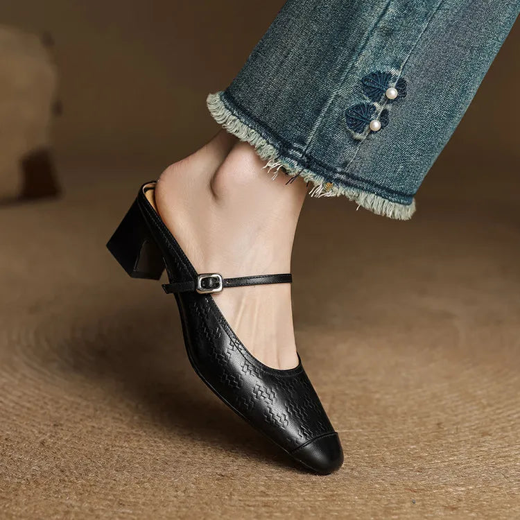 Black embossed leather mule with square toe, ankle strap, and block heel