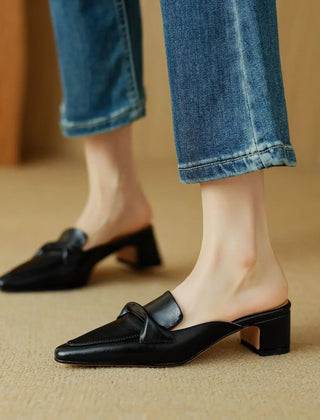 Black genuine leather mules with low block heel and slip-on loafer silhouette