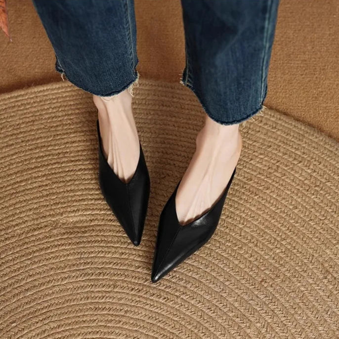 Black leather pointed-toe mules with low heel, angled rear view.
