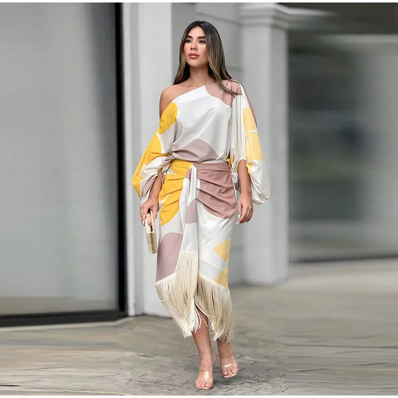 Model wearing abstract off-shoulder top and fringe-hem midi skirt in white and yellow