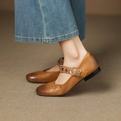 Tan leather flats with ankle buckle strap and decorative star-flower studs