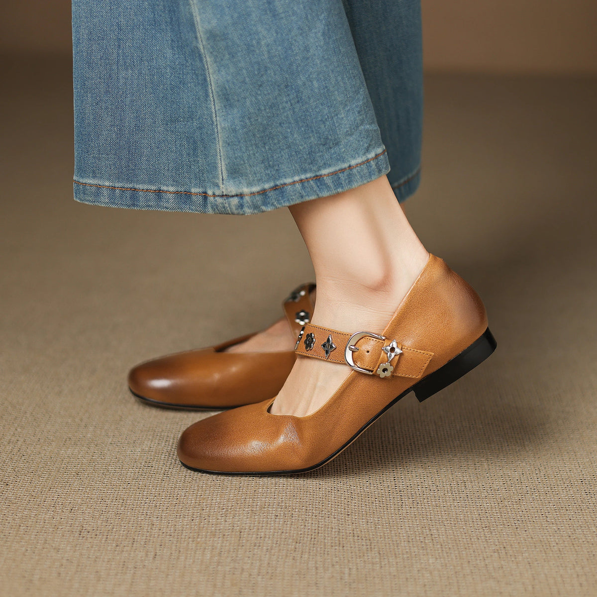 Tan leather flats with ankle buckle strap and decorative star-flower studs