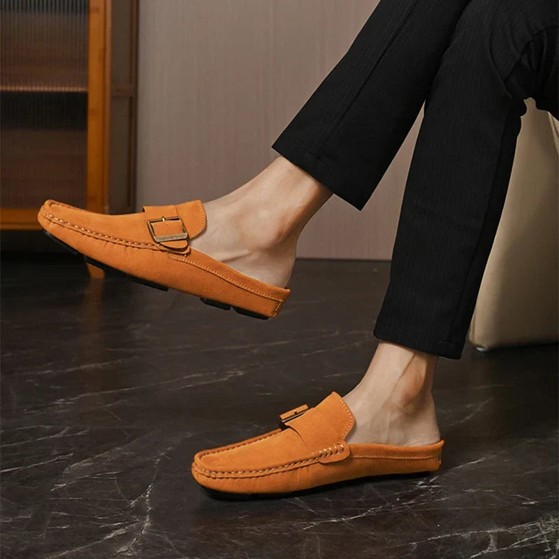 Tan suede mules with metal buckle strap and stitched side seam