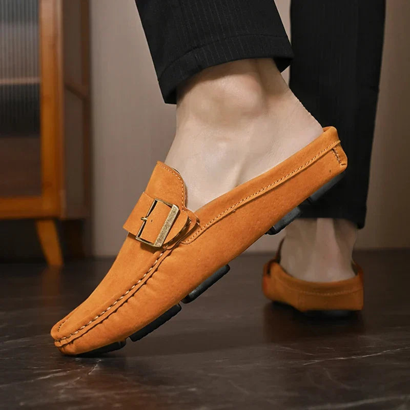 Tan suede mules with buckle strap worn with black pants