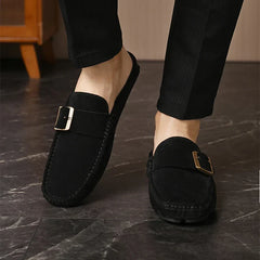 Black suede mules, slip-on design with square buckle strap and stitched detailing