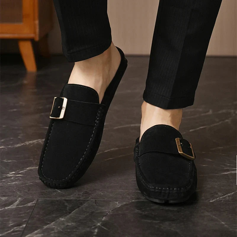 Black suede mules, slip-on design with square buckle strap and stitched detailing