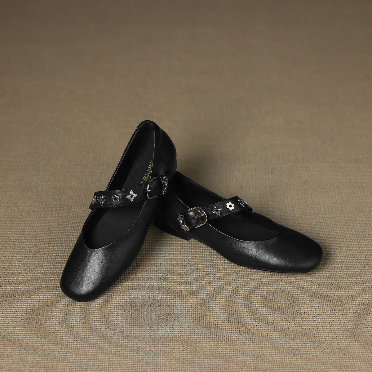 Black leather flats with decorative star strap and small buckle closure