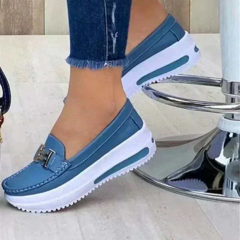 Sleek orthopedic loafers, light blue slip-on with buckle strap and white sole.