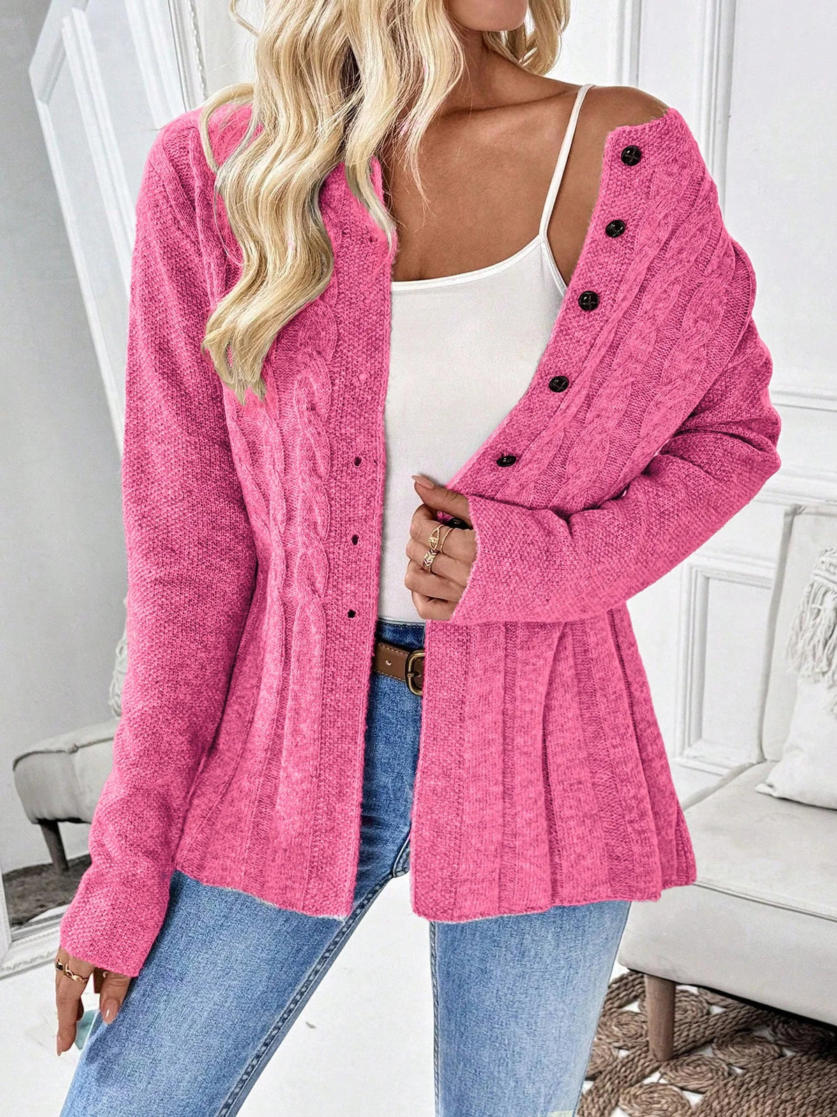 Pink ribbed cardigan with button front, long sleeves, and peplum hem
