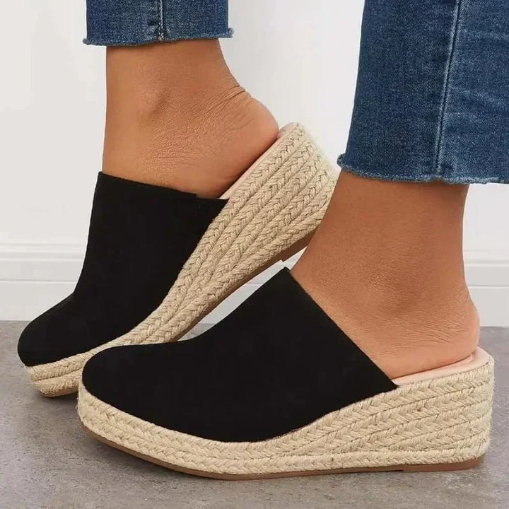 Black slip-on wedge sandals with textured jute sole and wide cushioned strap