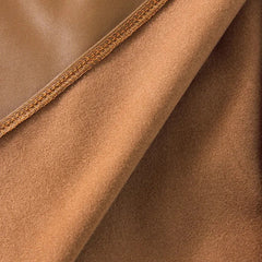 Close-up of brown leather skirt fabric with stitched edge seam detail