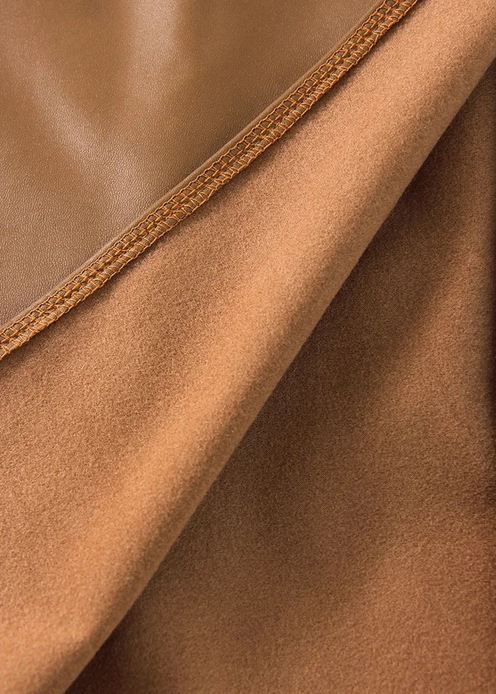 Close-up of brown leather skirt fabric with stitched edge seam detail