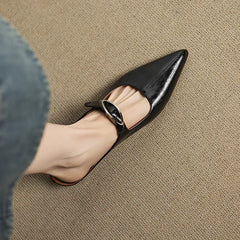 Black leather mules with pointed toe and slingback strap with silver buckle