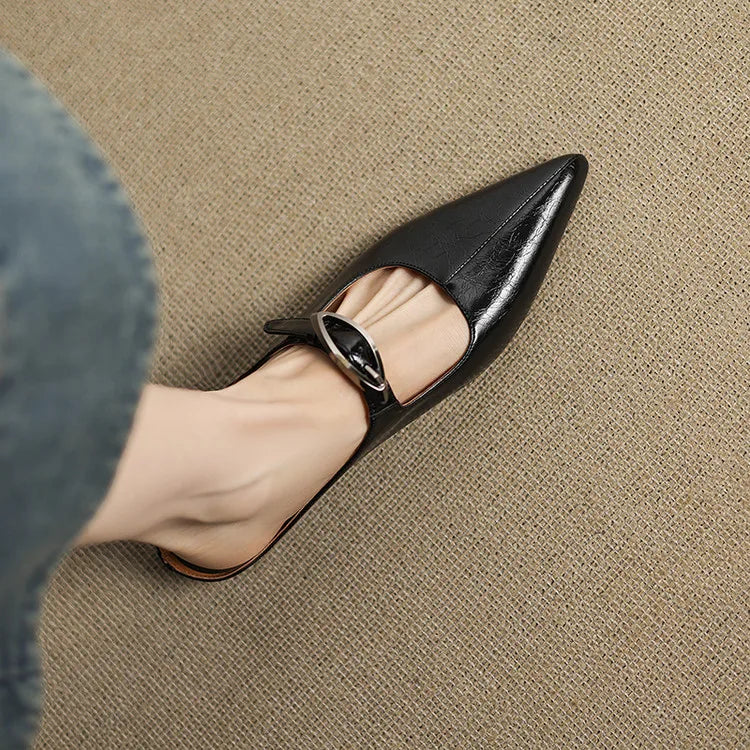 Black leather mules with pointed toe and slingback strap with silver buckle
