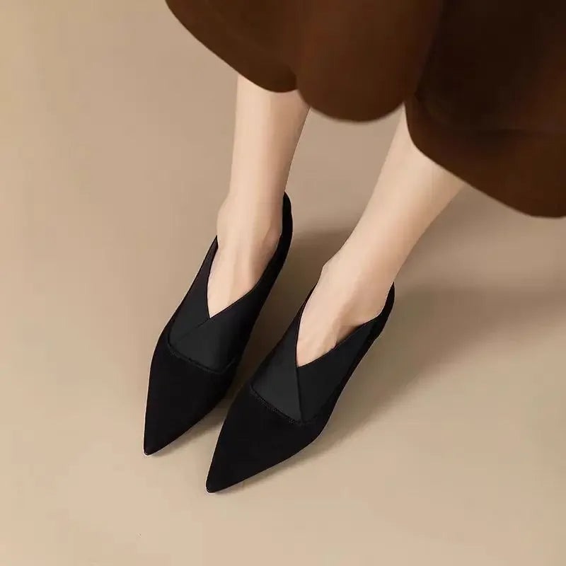 Black suede pointed-toe heels with mid heel, angled front view