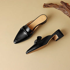 Black leather mules with pointed toe and low block heel, slip-on design.