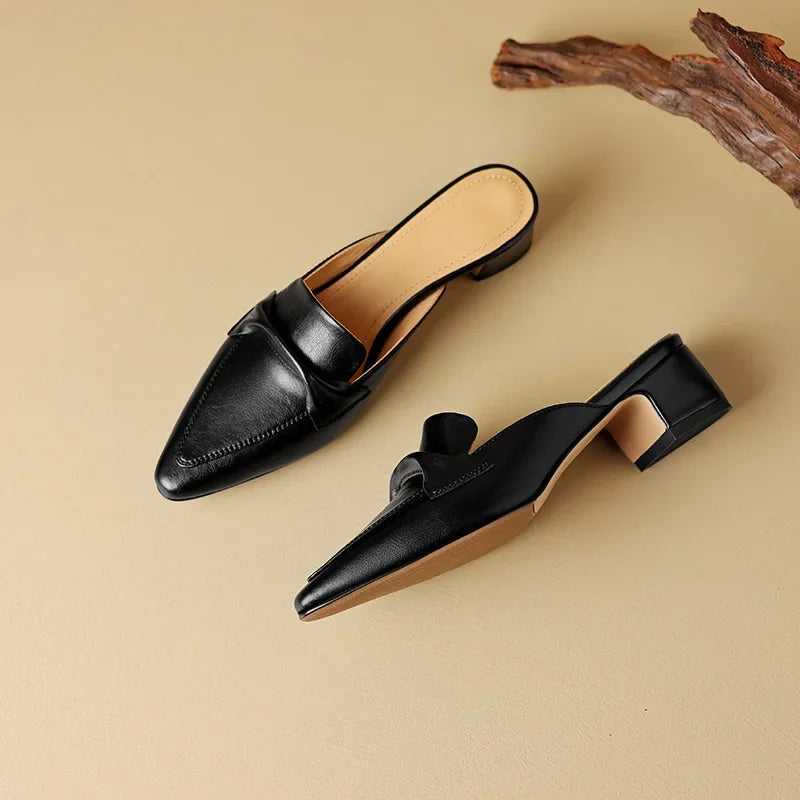 Black leather mules with pointed toe and low block heel, slip-on design.