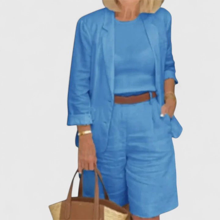 Blue 2-piece suit set with blazer jacket and shorts, styled with waist belt and tote