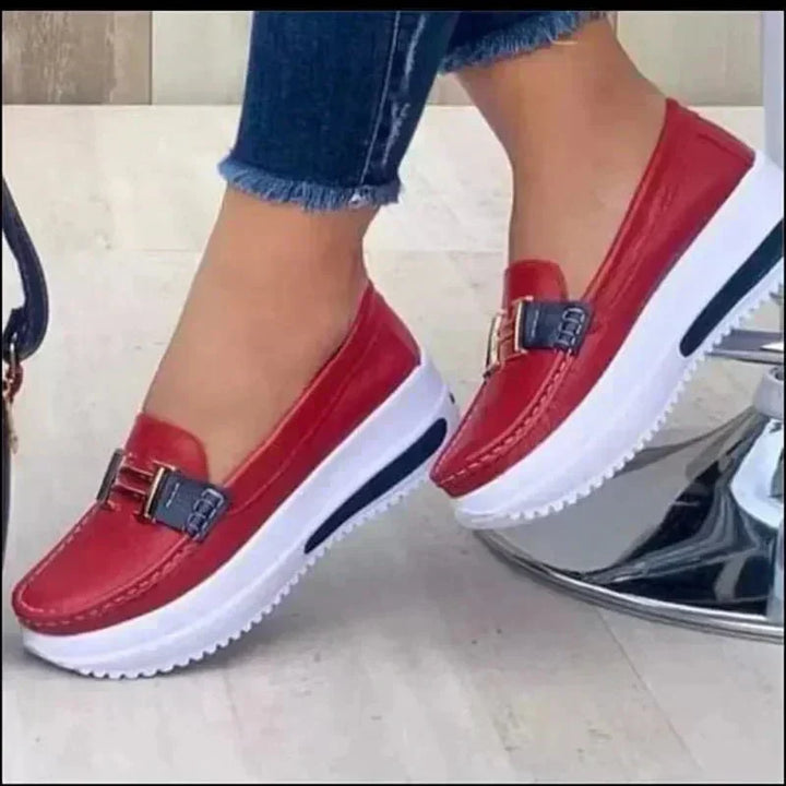 Sleek orthopedic loafers, red slip-on with buckle strap and white sole.