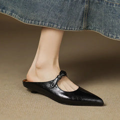Black leather pointed-toe mules with slingback strap and small buckle detail