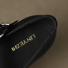 Black leather flat with gold-tone logo detail on the insole
