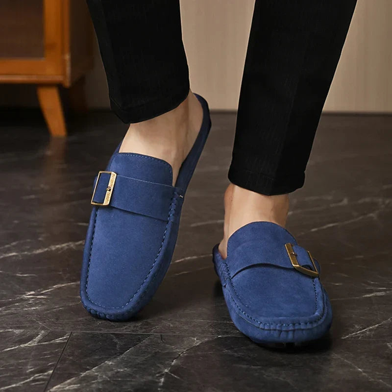 Blue suede mules with square buckle strap, low slip-on shoe on feet