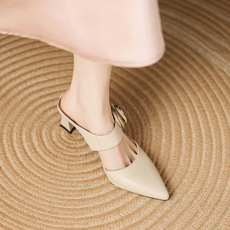 Beige leather heels featuring pointed toe and gold rosette ankle strap with block heel