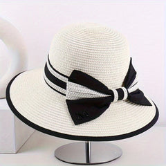 Ivory wide brim sun hat with black band, striped tie, and bow