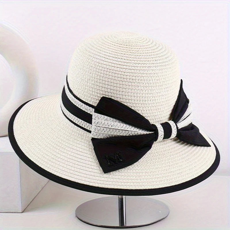 Ivory wide brim sun hat with black band, striped tie, and bow