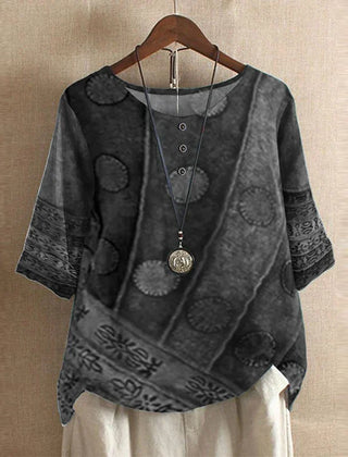 Women’s abstract floral blouse, dark gray with patterned motifs, short sleeves.